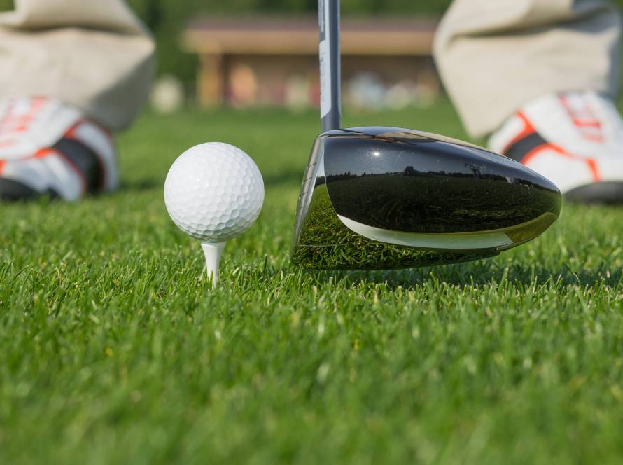 Close-up of a golf driver and ball at address, illustrating smash factor through ball speed and club speed, commonly analyzed in indoor golf simulators | Birdie Indoor Golf Center